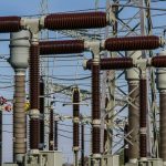 Detailed view of high voltage electrical substation with transformers and power lines.