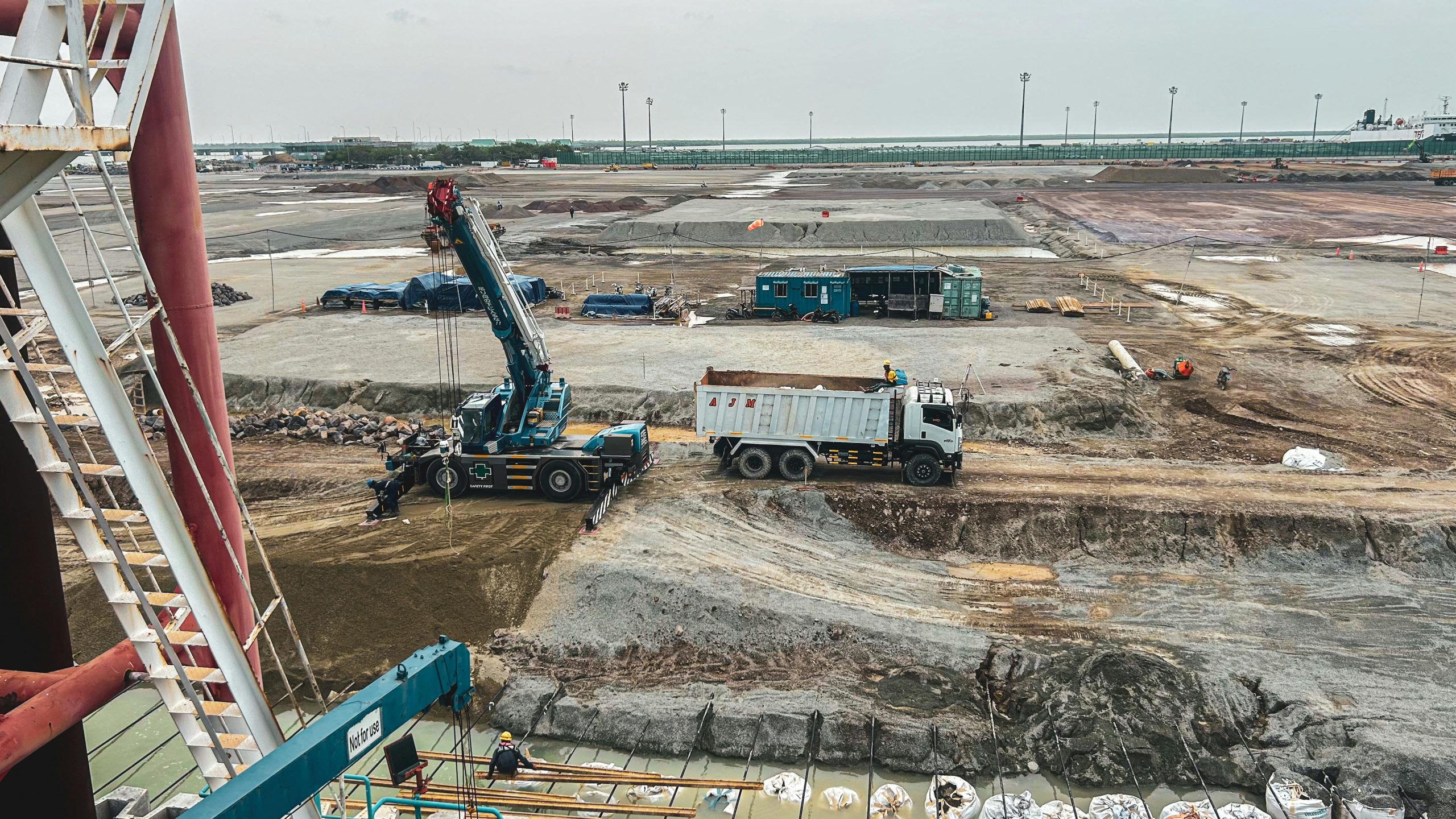 Aerial view of a construction site in West Java, Indonesia with crane and dump truck.