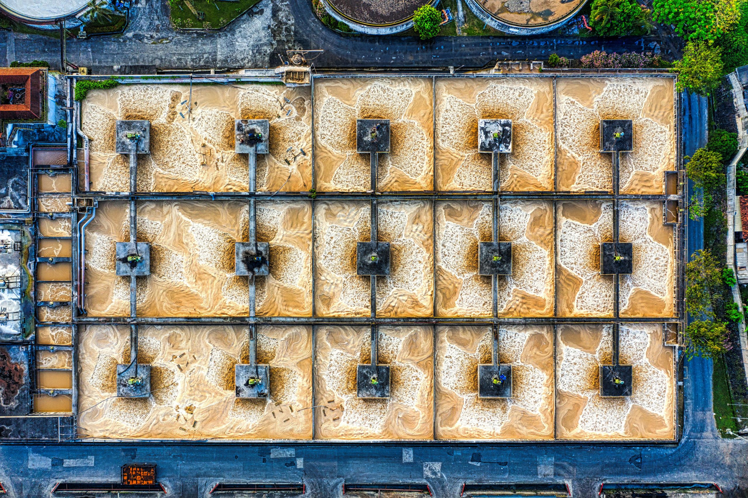 An aerial photo of a large industrial treatment plant in Indonesia, showcasing structured symmetry.