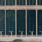 Top view of pisciculture complex with rectangular shaped tanks full of water between straight walkways in daylight