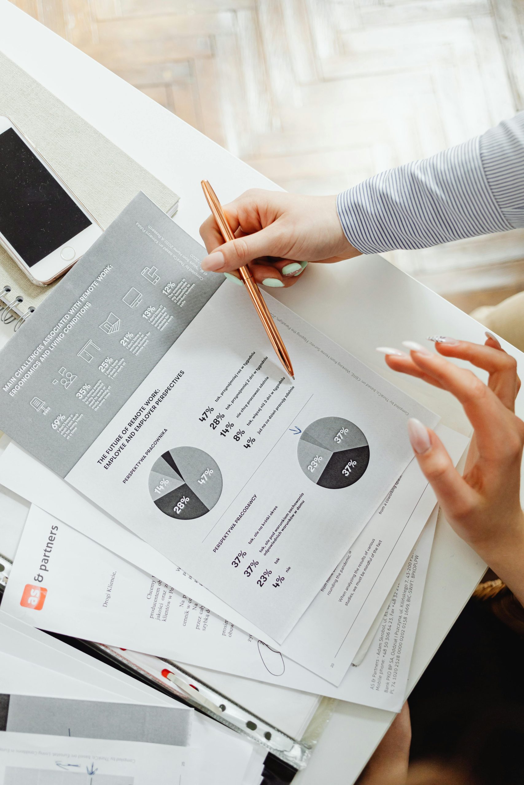 Design, Engineering & Project Management Close-up of businesswoman analyzing financial reports using pie charts in an office setting.